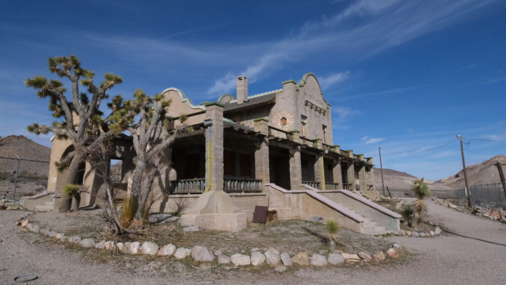 Rhyolite, near Las Vegas, is a well-preserved ghost town, featuring weathered buildings with the background of rugged desert terrain.