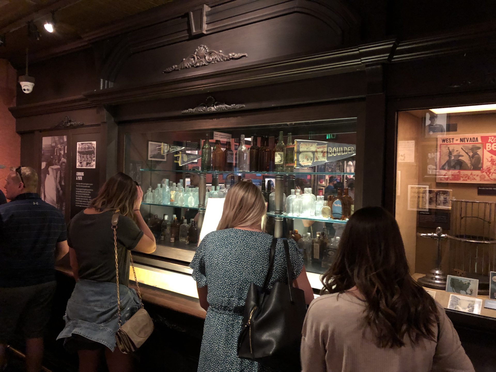 The inside of the Mob Museum in Downtown Las Vegas with visitors surrounding a glass display of organized crime and law enforcement and the historic brick building 