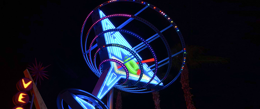 A upward shot of a Las Vegas LED sign of a alcohol drink with color rings surrounding it with the color blue glowing