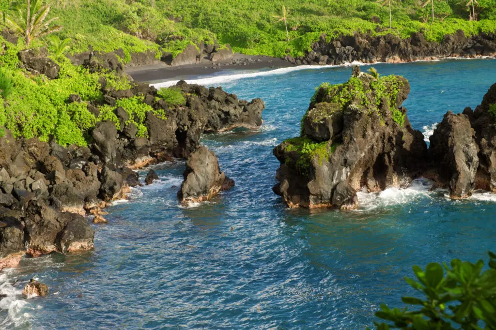 Located among abundant tropical foliage and dark lava cliffs, the stunning Pa'iloa Beach (Black Sand Beach) features a unique black pebble-sand blend that is unmatched globally. 