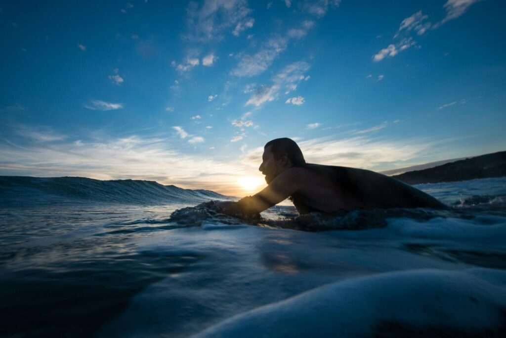 man paddling out to surf