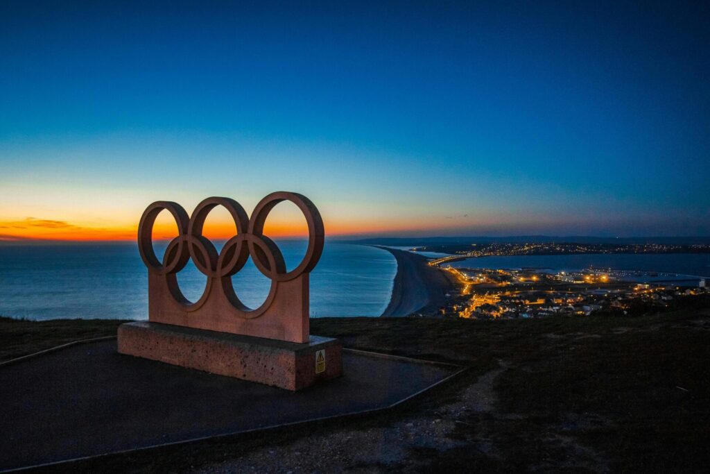 picture of the olympic logo statue with the sunset behind it