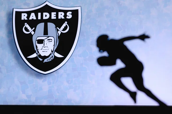 Las Vegas Raiders player in action on the field, showcasing team colors and logo during an intense football game